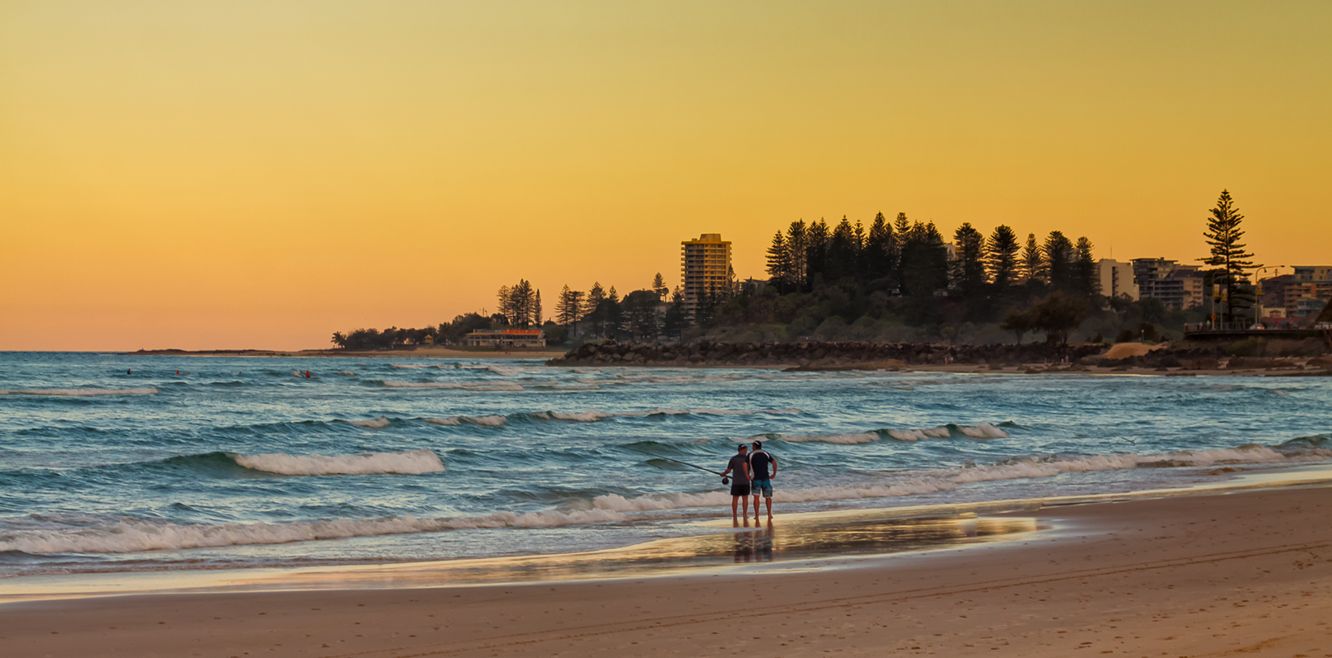 Two fishermen having a chat on a beach by Coolangatta, Queensland.