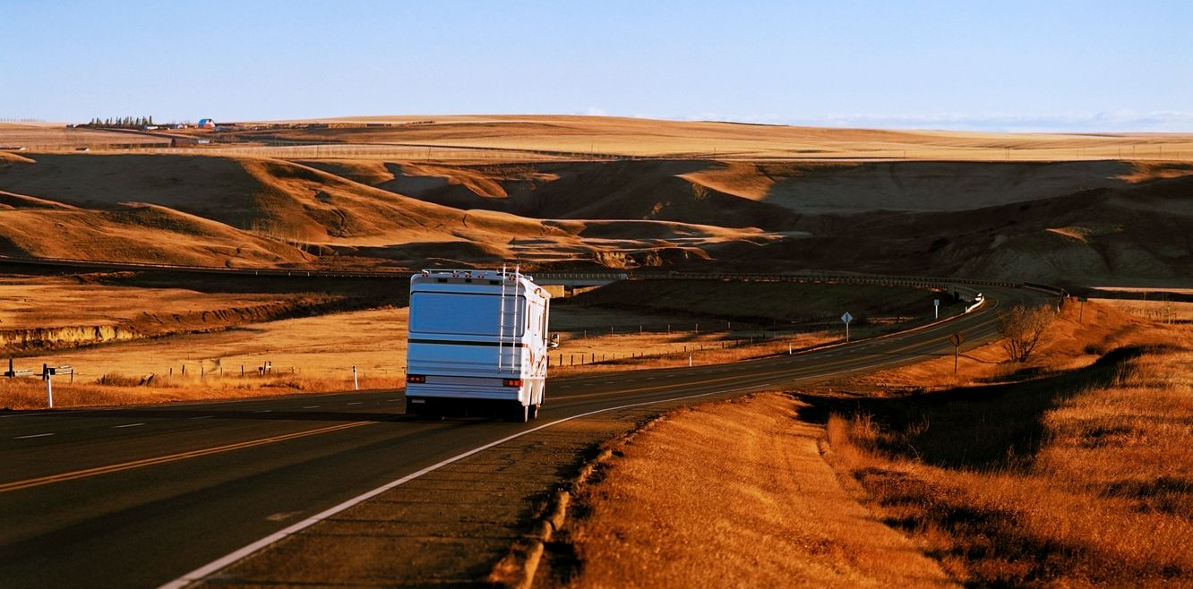 A campervan drives into the distance