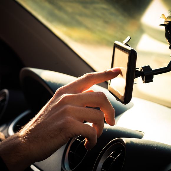 Man adjusting gps in car.