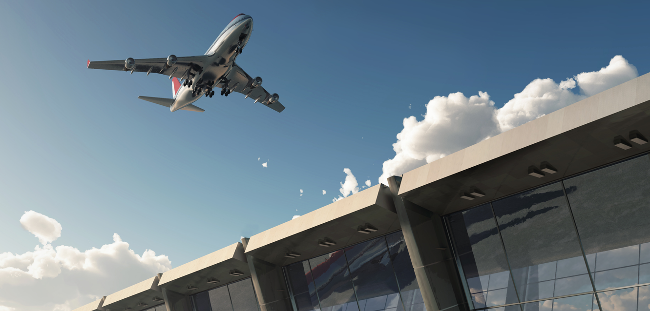 Aircraft taking off over a terminal building.